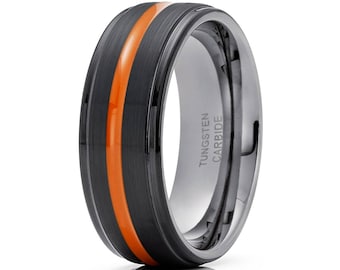 May include: A black tungsten carbide ring with an orange stripe. The ring is engraved with "TUNGSTEN CARBIDE".
