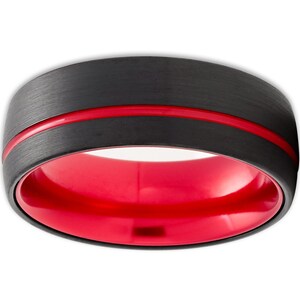 May include: A black tungsten carbide ring with a red inner band and a red line around the outer edge.