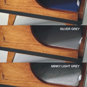 May include: A wooden cat bed with a curved opening and a removable cushion. The cushion is available in three colors: cobalt blue, silver grey, and minky light grey. The bed has a black trim around the edge and the brand name "Purrfur" is printed on the front.