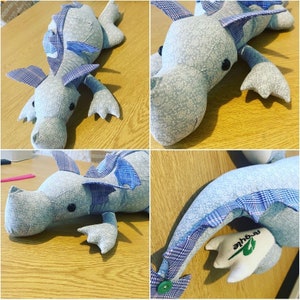 May include: A blue and white patchwork fabric dragon toy with a green leaf and the word "Arqile" on the tail.