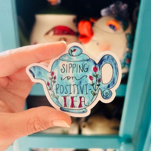 May include: A blue teapot sticker with pink flowers and the text "Sipping on Positivi-Tea".