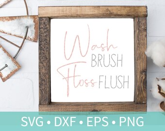 May include: A wooden sign with the text "Wash Brush Floss Flush" in pink and gray lettering. The sign is framed in a rustic brown wood frame.