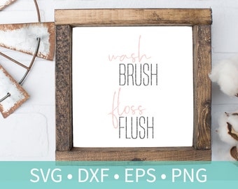 May include: A wooden framed sign with the text "wash brush floss flush" in black and pink lettering. The sign is on a white brick background with a metal windmill and cotton bolls on either side.