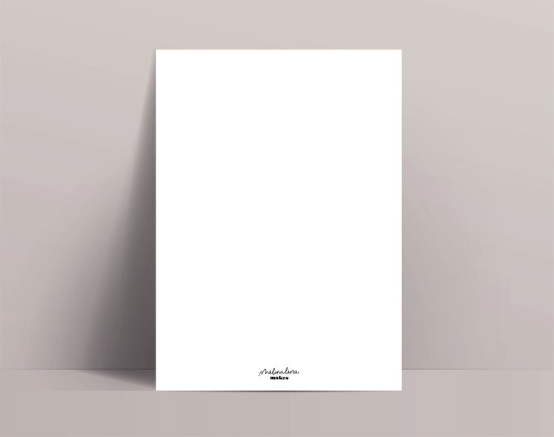 May include: A white rectangular print leaning against a light gray wall. The print has a small signature in the bottom right corner that reads "melrabina makes". The print is blank, with no visible design or text.