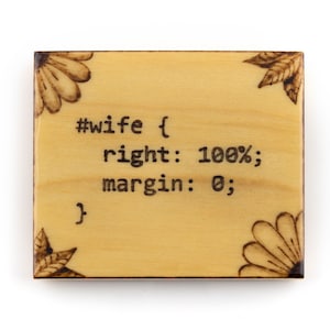 May include: A wooden sign with a floral design and the text "#wife { right: 100%; margin: 0; }" burned into the wood.