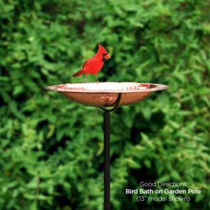 May include: A red cardinal bird perched on the edge of a copper bird bath on a black metal garden pole. The bird bath is 13 inches in diameter. Good Directions Bird Bath on Garden Pole (13" model shown)