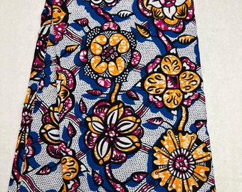 May include: Folded fabric with a vibrant floral pattern. The design features large flowers in shades of orange, pink, and white, set against a blue and white dotted background. The fabric has a tag that says "wax" and "GUARANTEED BLOCK PRINTS!"