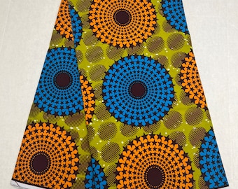 May include: A green fabric with a repeating pattern of orange and blue circles with brown centres. The circles are surrounded by a ring of stars. The fabric has a white border with the text "Hitarget" printed on it.