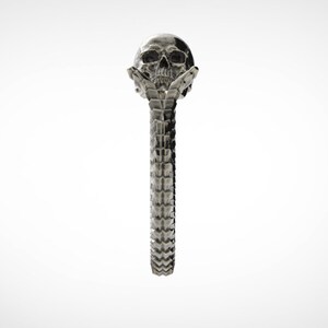 May include: A silver skull ring with a detailed design. The skull is holding its own head in its hands.