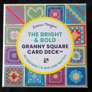 Puede incluir: Una baraja de cartas titulada "The Bright & Bold Granny Square Card Deck" de Leonie Morgan. La caja presenta una cuadrícula de coloridos cuadrados de ganchillo. La baraja contiene 50 diseños para mezclar y combinar.