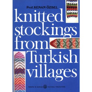Puede incluir: Portada de libro con el título "knitted stockings from Turkish villages" de Prof. Kenan Özbel. La portada presenta un fondo azul con calcetines de punto de colores.