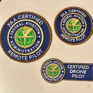 May include: Three embroidered patches with the text "FAA CERTIFIED" and "FEDERAL AVIATION ADMINISTRATION REMOTE PILOT". One patch is rectangular and reads "CERTIFIED DRONE PILOT". The patches are navy blue with gold and green accents.