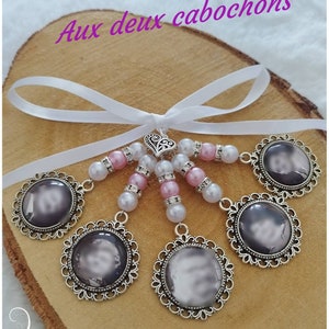 May include: A handmade photo charm with six circular pendants featuring a grayscale image, each framed in ornate silver filigree. The charms are connected by pink and white beads, a silver heart, and a white ribbon. The text "Aux deux cabochons" is visible.