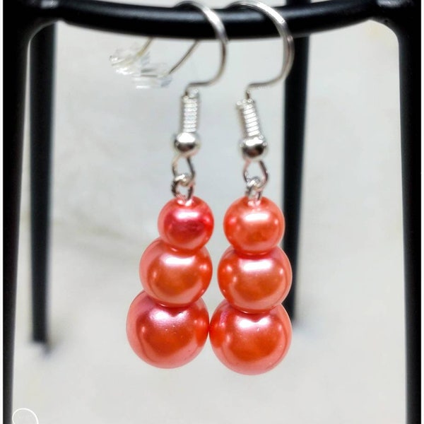 Bijou boucle d'oreilles pendantes 3 perles coloris corail, attache par crochet et Fermoir silicone finesse et élégance.