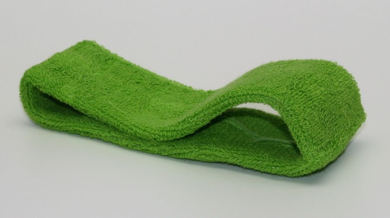 Peut inclure: Un bandeau vert vif en tissu &eacute;ponge doux. Le bandeau est pli&eacute; en deux et pr&ecirc;t &agrave; &ecirc;tre port&eacute;.