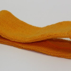 Peut inclure: Un bandeau jaune vif en tissu doux et extensible. Le bandeau est pli&eacute; en deux et pr&ecirc;t &agrave; &ecirc;tre port&eacute;.