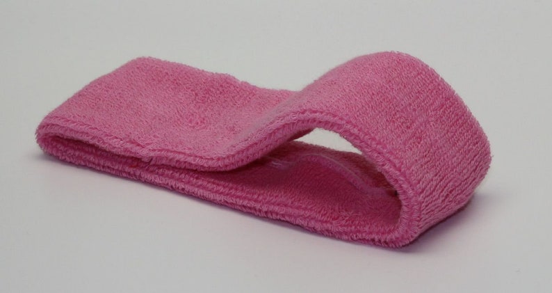 Peut inclure: Un bandeau rose en tissu &eacute;ponge doux. Le bandeau est pli&eacute; en deux et pr&ecirc;t &agrave; &ecirc;tre port&eacute;.