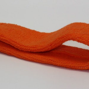 Peut inclure: Un bandeau orange en tissu doux et extensible. Le bandeau est pli&eacute; en deux et pr&ecirc;t &agrave; &ecirc;tre port&eacute;.