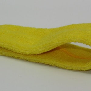 Peut inclure: Un bandeau jaune en tissu doux et absorbant. Il est con&ccedil;u pour &ecirc;tre port&eacute; autour du front afin d'absorber la transpiration et de garder les cheveux hors du visage.