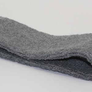 Peut inclure: Un bandeau gris en tissu doux et textur&eacute;. Il est pli&eacute; en deux et semble &ecirc;tre fait de tissu &eacute;ponge.