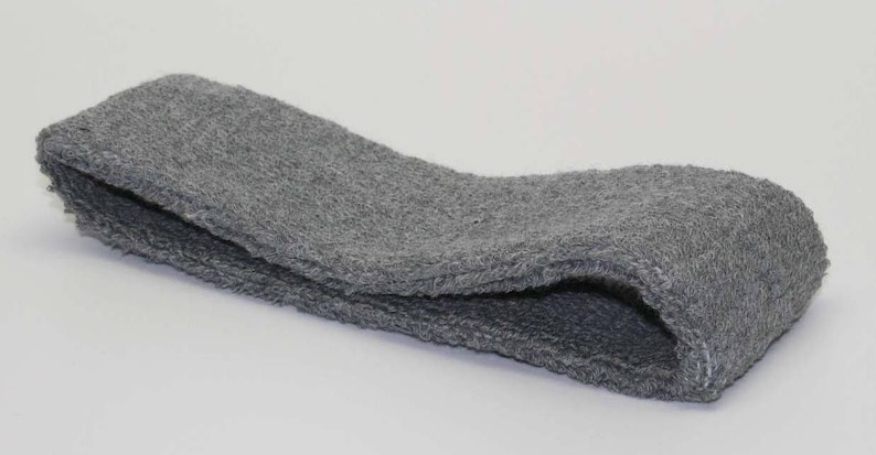 Peut inclure: Un bandeau gris en tissu doux et textur&eacute;. Il est pli&eacute; en deux et semble &ecirc;tre fait de tissu &eacute;ponge.