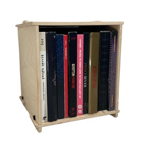 May include: A wooden record storage crate holding several vinyl records. The records have various album covers, including "blonde redhead" and "Led Zeppelin". The crate is made of light-colored wood and has a simple, functional design.