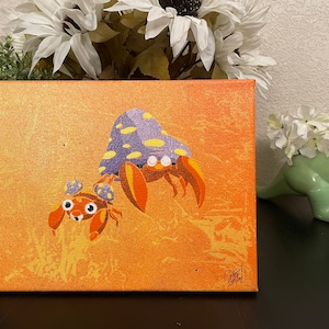 May include: A hand-painted canvas featuring two cartoon crabs. The larger crab is wearing a purple and yellow shell with white spots. The smaller crab is orange and has large, white eyes. The background is a gradient of orange and yellow.