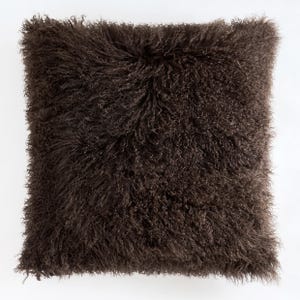 May include: A square decorative pillow with a shaggy, textured appearance. The pillow is a deep brown color, with long, curly fibers creating a plush, inviting look. The pillow's design suggests a focus on comfort and home decor.