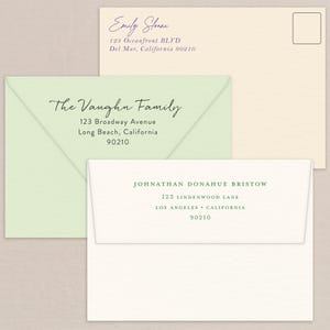 Könnte beinhalten: Drei Umschläge mit aufgedruckten Adressen. Der obere Umschlag ist cremefarben mit dem Namen "Emily Sloane" in violetter Tinte. Der mittlere Umschlag ist hellgrün mit "The Vaughn Family" in schwarzer Tinte. Der untere Umschlag ist weiß mit "JOHNATHAN DONAHUE BRISTOW" in grüner Tinte.