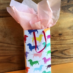 A gift bag made from dachshund giftwrap with pink tissue paper