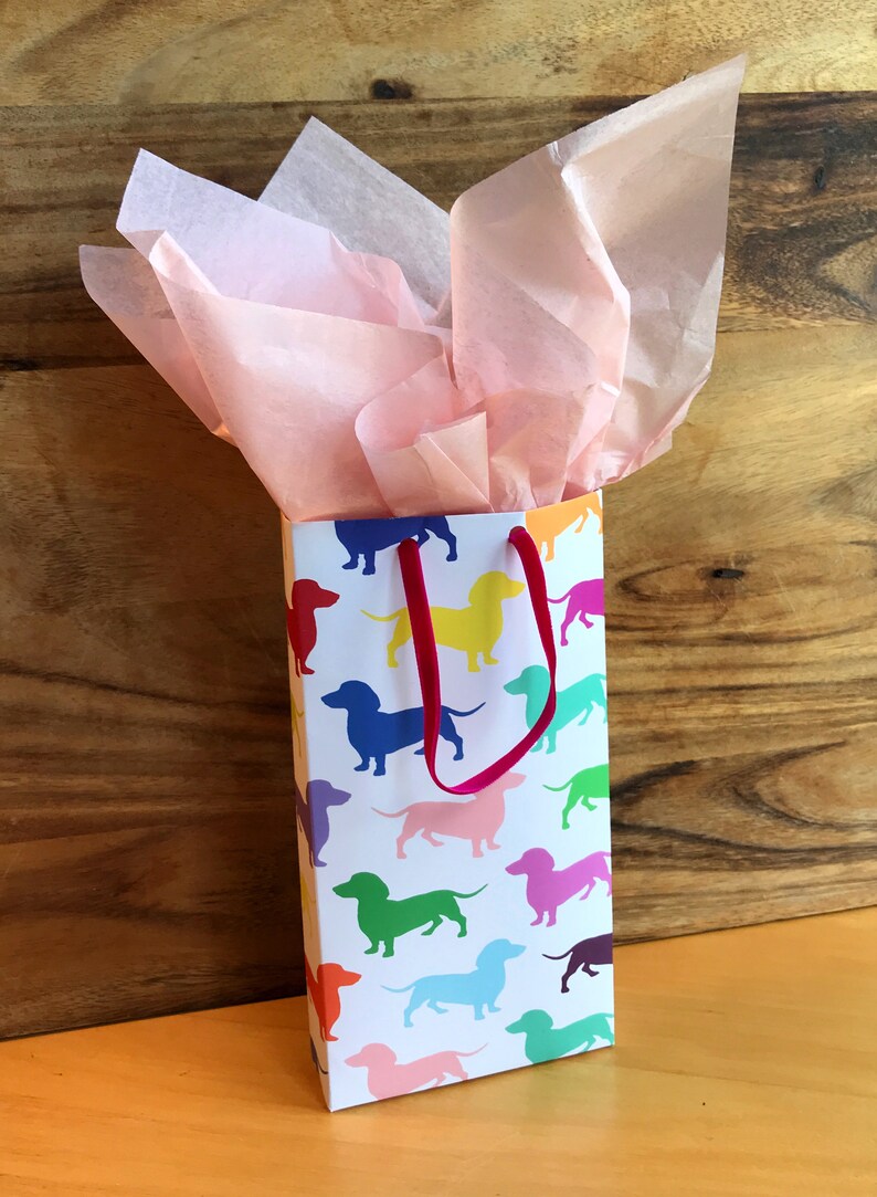A gift bag made from dachshund giftwrap with pink tissue paper