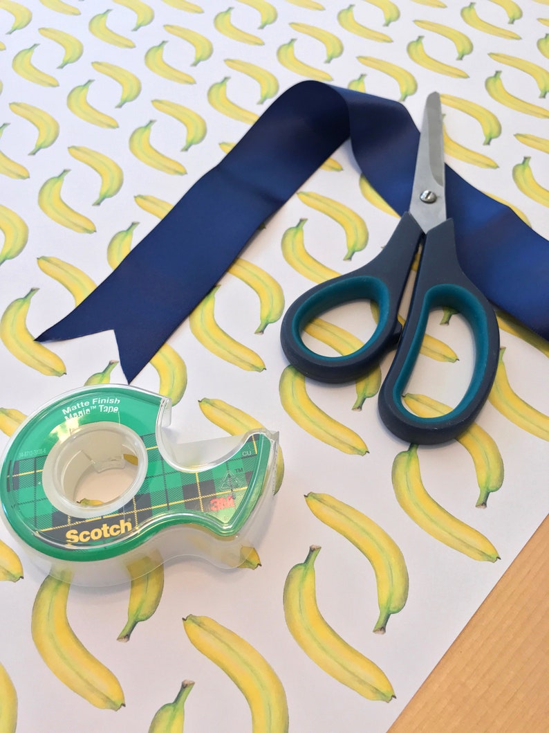 Close-up of banana giftwrap with scissors and tape for size