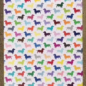 An entire sheet of dachshund wrapping paper showing the playful pattern of many colored dogs.