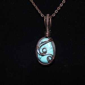 May include: A turquoise gemstone pendant wrapped in copper wire with a delicate, swirling design. The pendant hangs from a copper chain.