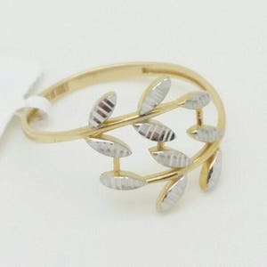 May include: A gold ring with a delicate design of two intertwined branches with leaves. The leaves are textured and have a two-tone finish.