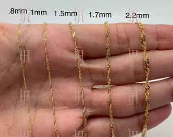 May include: Five gold chains of different thicknesses, ranging from 0.8mm to 2.2mm, are displayed on a hand. The chains are all made of a twisted rope design.