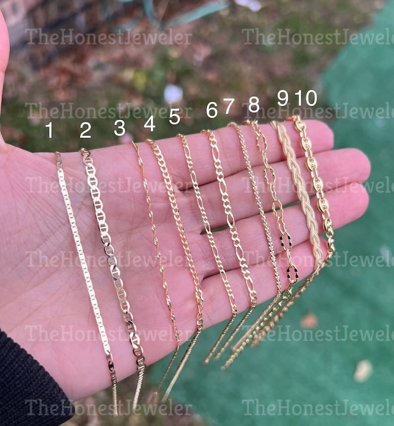 May include: Ten gold chains of different styles and lengths, numbered 1 through 10. The chains are displayed on a hand, with the numbers visible above each chain.