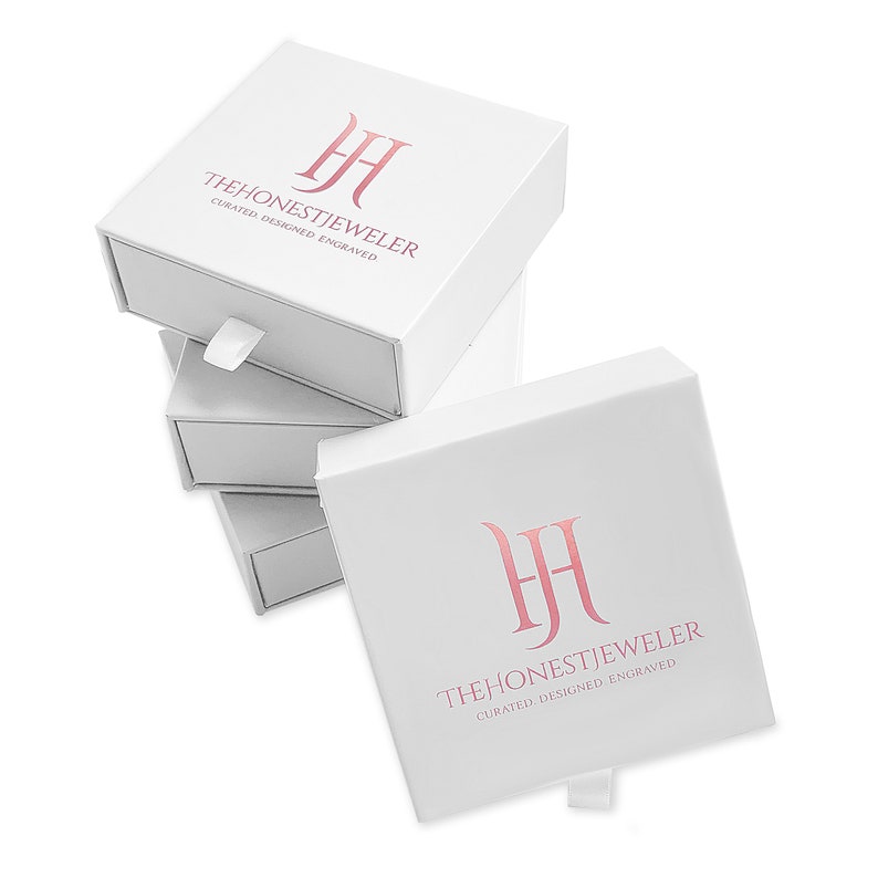 May include: Stack of white gift boxes with a pink logo that reads "THE HONEST JEWELER CURATED. DESIGNED. ENGRAVED."