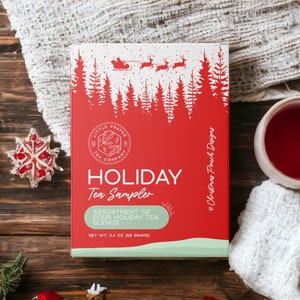 May include: A red and white Holiday Tea Sampler box with a Christmas theme, featuring a Santa sleigh design. The box contains an assortment of four holiday tea blends, net weight 2.4 oz (68 grams). The image includes a cup of tea and Christmas ornaments.