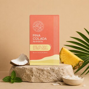 以下が含まれることがあります： サンゴと黄色のデザインの「Pina Colada」ルーズハーブティーの箱が石の上にあります。箱の隣にはパイナップルのスライス、ココナッツ、ミントがあります。お茶の箱には「クリーミーなココナッツとフルーティーなパイナップルのヒントを含む甘くてトロピカルなノート」と書かれています。