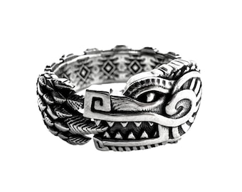 May include: A silver ring with a detailed design of a wolf's head. The ring is made of a braided band with a geometric pattern.