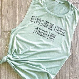 May include: A light green sleeveless shirt with the text "All I need is food, love, & exercise. I'm basically a puppy." printed in black.