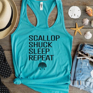 May include: A turquoise tank top with black text that reads "Scallop Shuck Sleep Repeat" and a black scallop shell graphic.