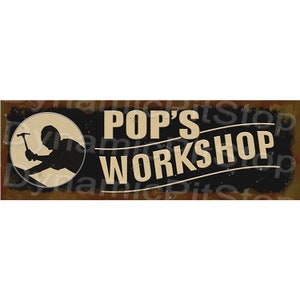 May include: A rectangular sign with the words "POP'S WORKSHOP" in a vintage font. The sign features a circular emblem with a silhouette of a person working with a hammer. The background is a mix of black, brown, and tan.
