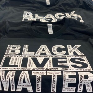 May include: Black Lives Matter t-shirt with a white print of names of people who have been killed by police brutality. The names are arranged in a circle around the words "Black Lives Matter".