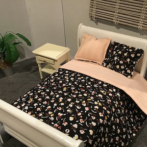 May include: A white sleigh bed with a black and white floral patterned duvet and two pillows. One pillow is pink and the other is black and white floral.