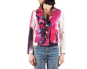 May include: A white blazer with a pink, black, and blue abstract print. The blazer has a notched collar, long sleeves, and two front pockets.