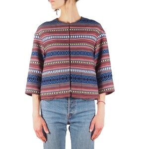 Puede incluir: Chaqueta estampada con un diseño vibrante. La chaqueta presenta una mezcla de rayas horizontales rojas, azules y amarillas. Tiene mangas tres cuartos y un corte recto, con una parte delantera sencilla y abierta. Se usa con vaqueros azules.