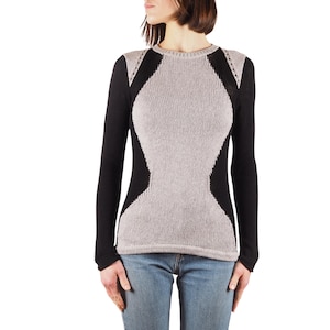 May include: A long-sleeved sweater with a black and gray color block design. The sweater has a round neckline and a fitted silhouette.