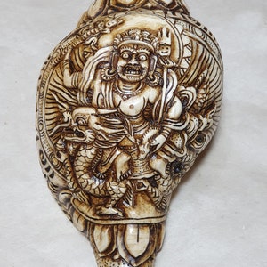 Handcarved Conch Shell Zambala riding a Dragon. 100 % Handmade from Nepal
